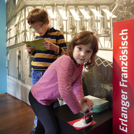 Kinder stempeln ihren &quot;Reisepass&quot; in der Ausstellung &quot;Vielfraß meets Butterkeks&quot;