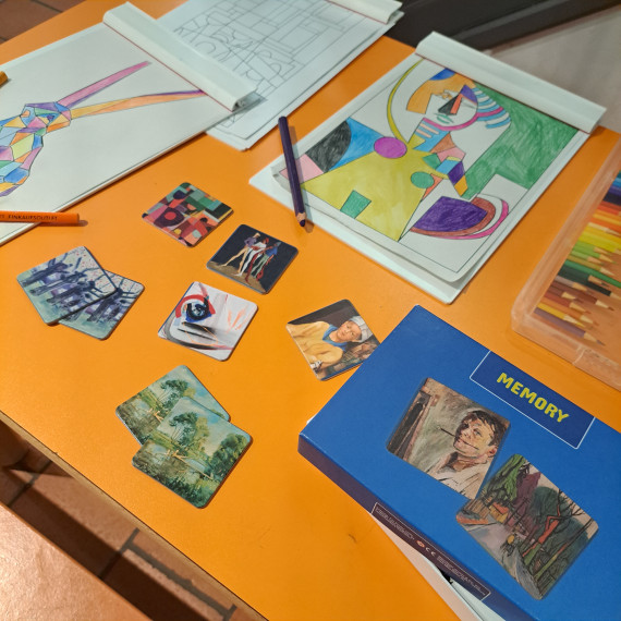 Spieltisch im Museum mit Ausmalbildern, Stiften und einem Kunst-Memory