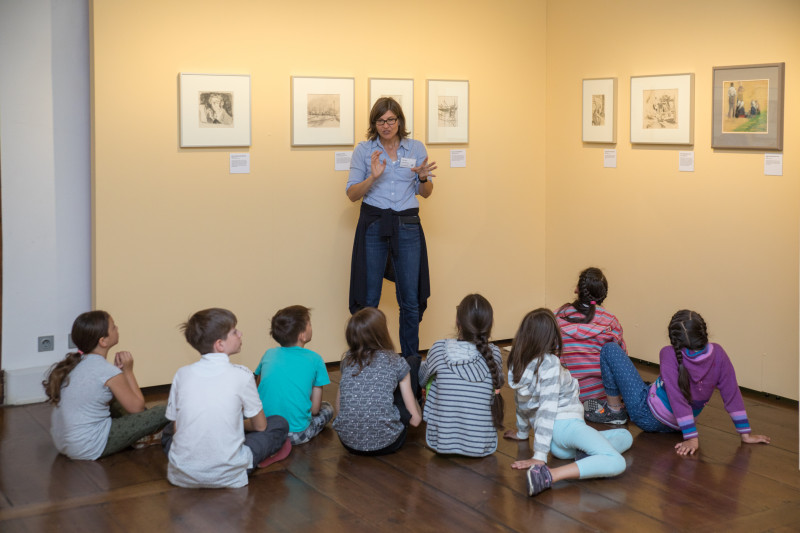 Drei lachende Schüler vor dem Haupteingang des Museums